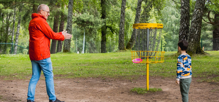 Familj spelar discgolf